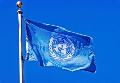 un flag flying pole blue sky behind it rsz