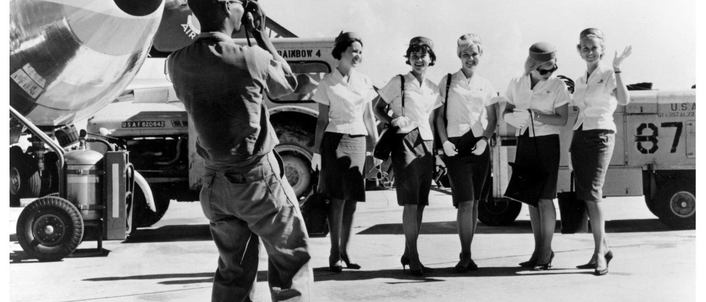 Group photo of flight attendants and photographer, 1960s